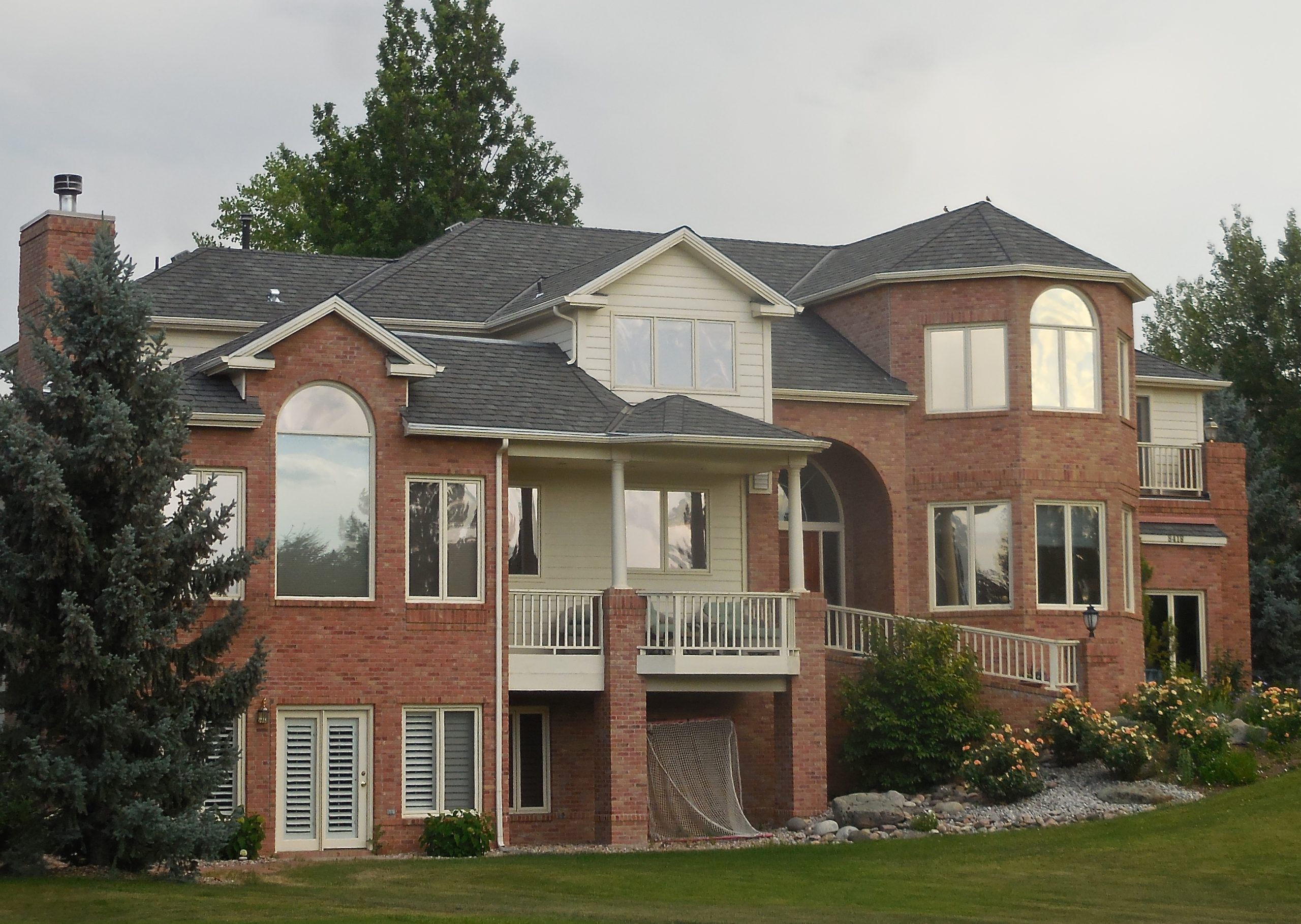 large brick home with asphalt roofing